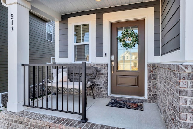 doorway to property featuring stone siding and a porch