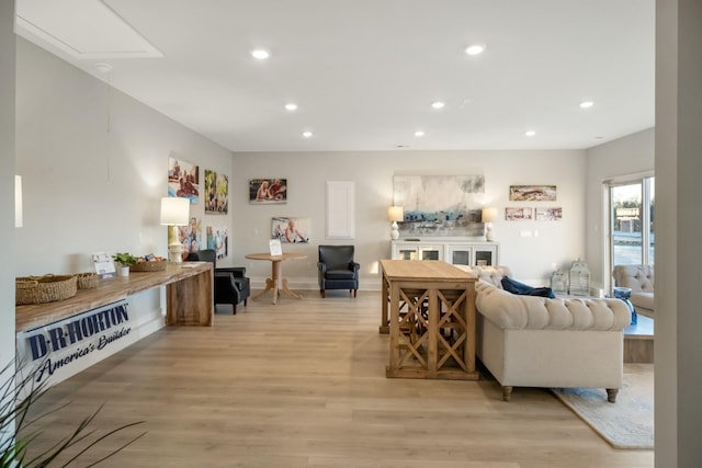 living area featuring attic access, light wood-style flooring, recessed lighting, and baseboards