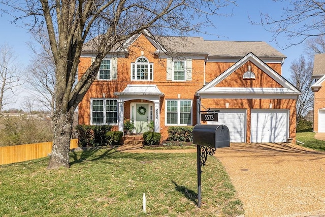 view of front of house with brick siding, driveway, a front lawn, and fence