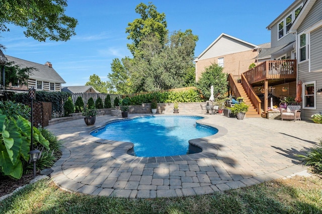 view of pool with a patio, fence, stairway, a wooden deck, and a fenced in pool