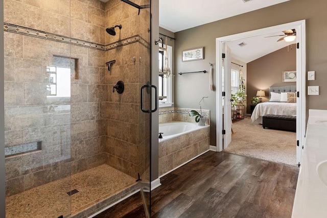 bathroom with wood finished floors, ensuite bath, a shower stall, vaulted ceiling, and a garden tub