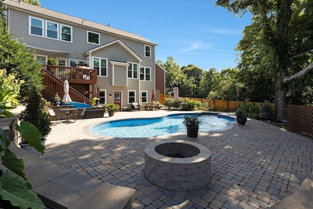 view of swimming pool with a patio, an outdoor fire pit, a deck, and fence