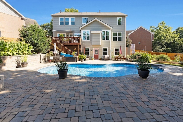 view of pool with stairs, a patio, fence, and a wooden deck