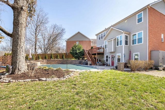 rear view of property featuring a yard, fence, a deck, and stairway