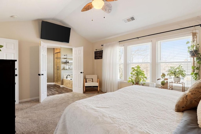 carpeted bedroom with visible vents, connected bathroom, baseboards, lofted ceiling, and a ceiling fan