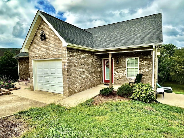 view of front of home featuring brick siding, a shingled roof, a front yard, a garage, and driveway