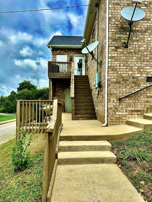 property entrance with brick siding and a deck