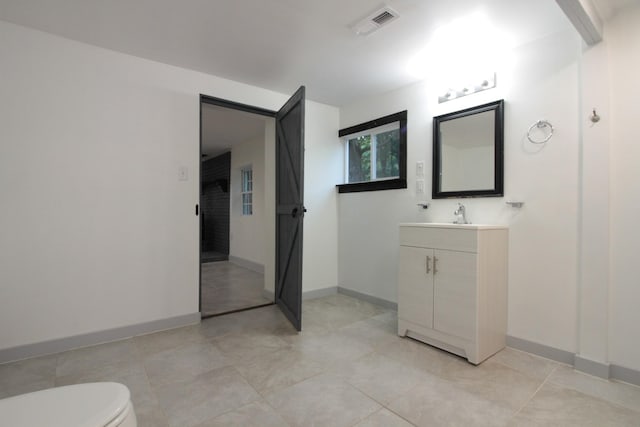 bathroom featuring vanity, toilet, baseboards, and visible vents