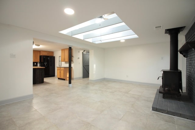 living area featuring recessed lighting, visible vents, baseboards, and a wood stove