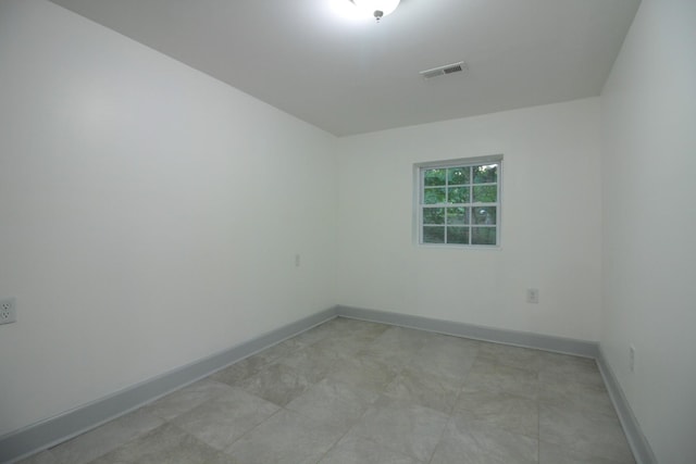 spare room with baseboards and visible vents