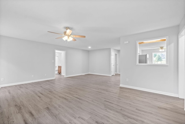 empty room with baseboards, wood finished floors, and ceiling fan