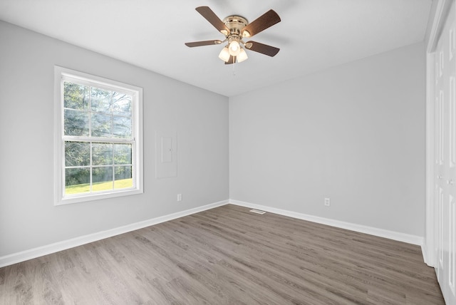 unfurnished room featuring a ceiling fan, wood finished floors, and baseboards