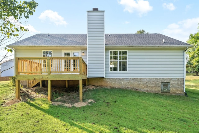 rear view of property featuring a wooden deck, a chimney, a shingled roof, and a yard