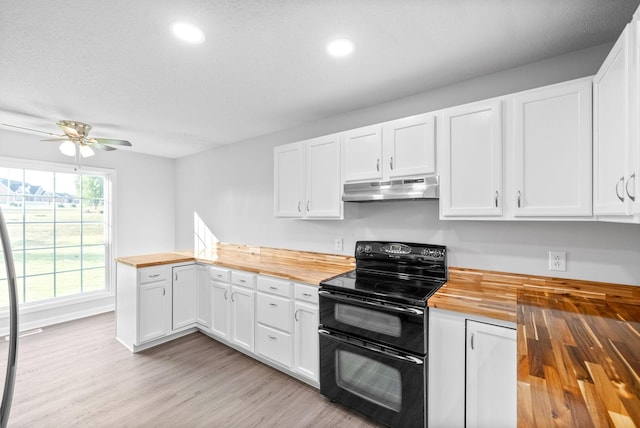 kitchen with wooden counters, a peninsula, range with two ovens, light wood-style flooring, and under cabinet range hood