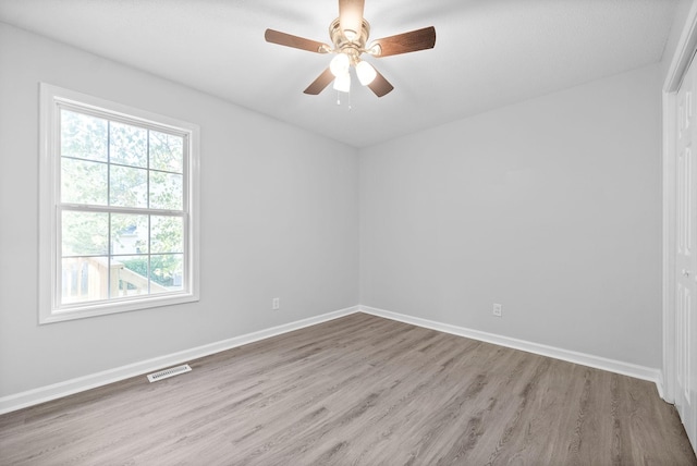 unfurnished room featuring visible vents, a ceiling fan, baseboards, and wood finished floors