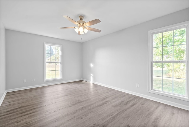 unfurnished room with wood finished floors, baseboards, and ceiling fan