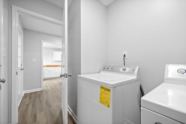 laundry room with washer and dryer, laundry area, baseboards, and light wood finished floors