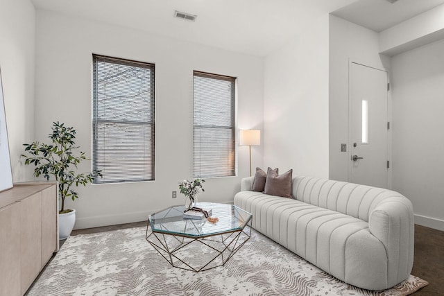 living area with a wealth of natural light, visible vents, and baseboards