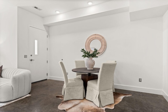 dining room with visible vents, baseboards, and finished concrete floors