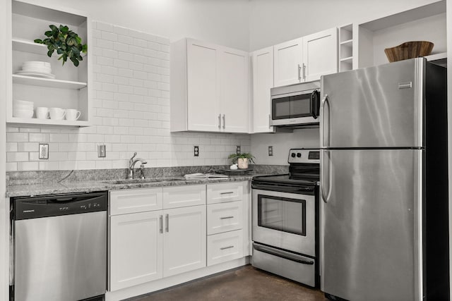 kitchen featuring open shelves, light stone countertops, appliances with stainless steel finishes, white cabinetry, and a sink