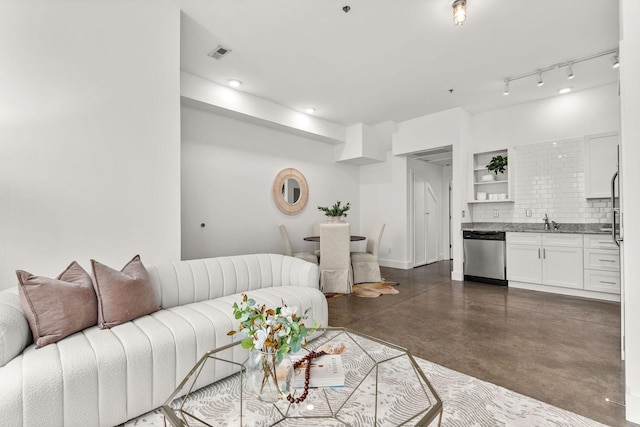 living area with visible vents, concrete flooring, and baseboards