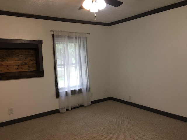 spare room featuring a wealth of natural light, light colored carpet, ceiling fan, and ornamental molding