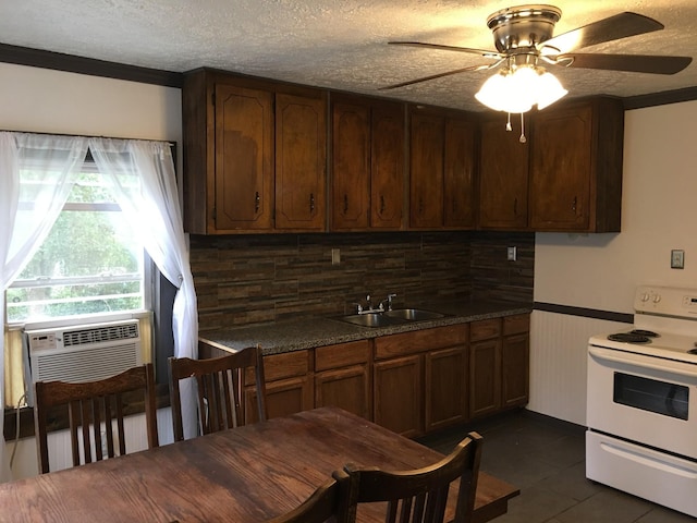 kitchen featuring a ceiling fan, a sink, electric stove, a textured ceiling, and dark countertops