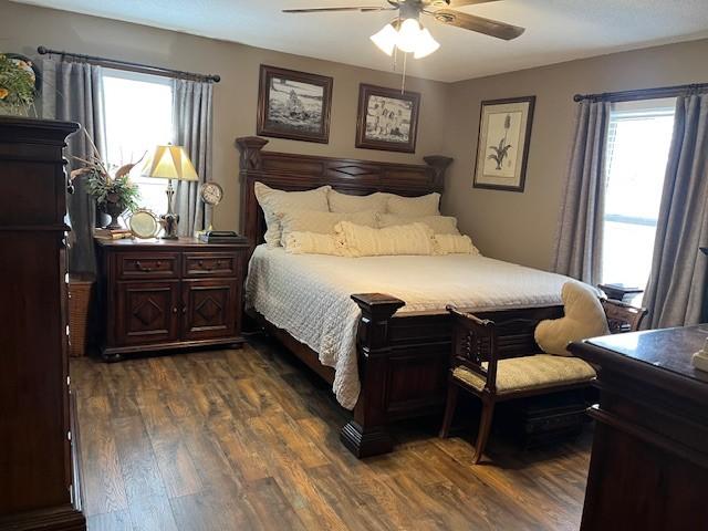 bedroom with dark wood-type flooring and a ceiling fan