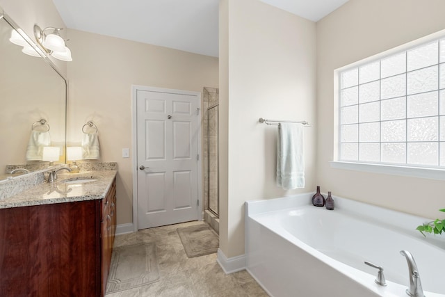 full bath with baseboards, a garden tub, a shower stall, and vanity