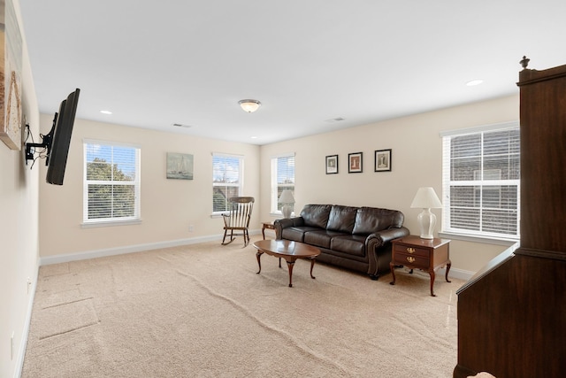 living area with recessed lighting, visible vents, light colored carpet, and baseboards