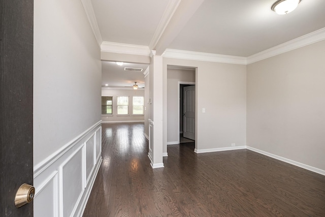 empty room with visible vents, ceiling fan, dark wood-type flooring, crown molding, and a decorative wall