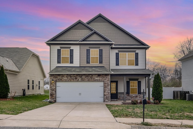 craftsman inspired home with a front yard, fence, covered porch, and driveway