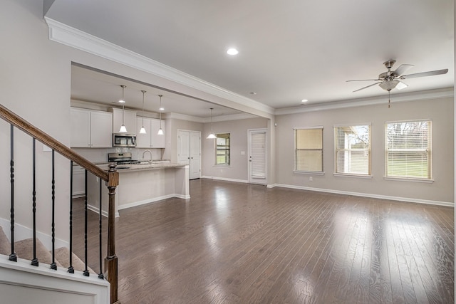 unfurnished living room featuring crown molding, baseboards, ceiling fan, stairs, and dark wood-style floors