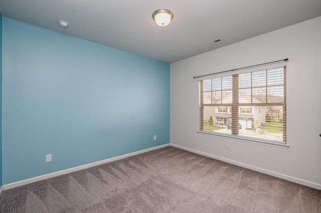 empty room with visible vents, baseboards, and carpet flooring