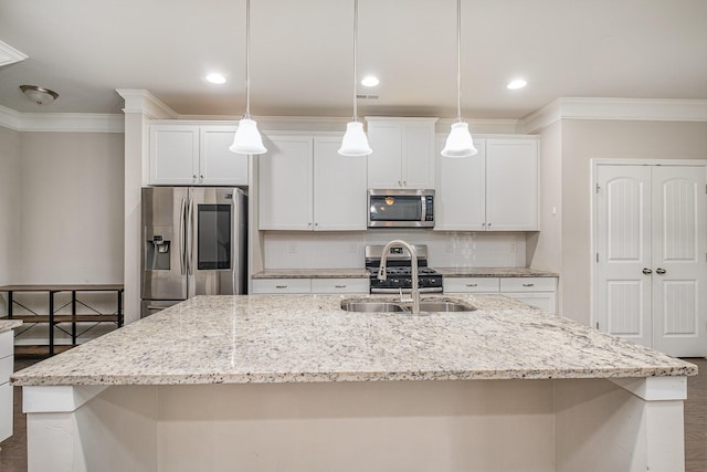 kitchen featuring crown molding, a center island with sink, decorative backsplash, stainless steel appliances, and a sink