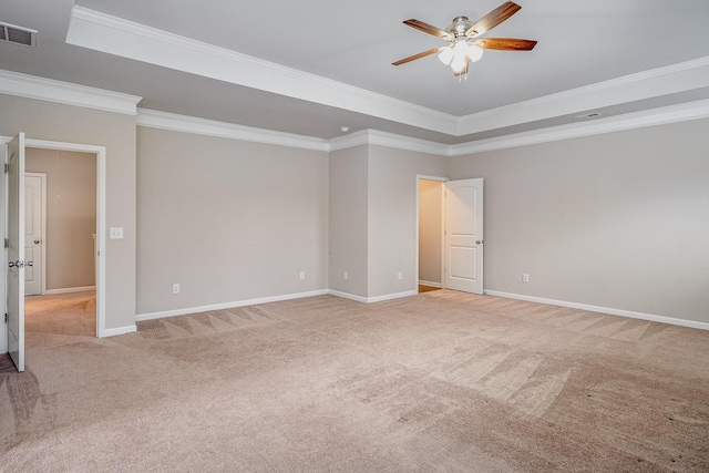 spare room with visible vents, light carpet, a raised ceiling, and ceiling fan