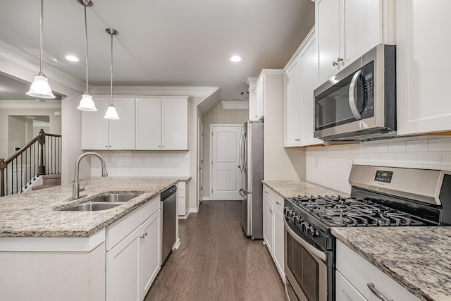 kitchen with a sink, stainless steel appliances, white cabinets, and crown molding