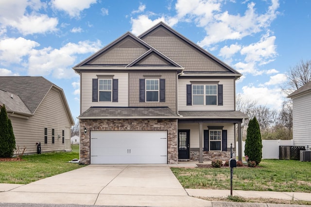 craftsman-style house with fence, a front yard, covered porch, a garage, and driveway