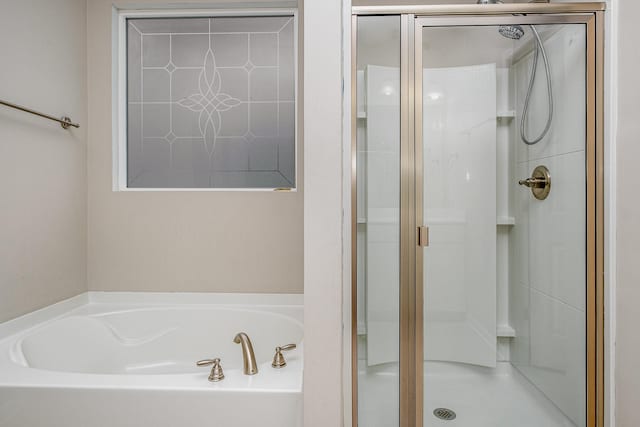 bathroom with a bath and a shower stall