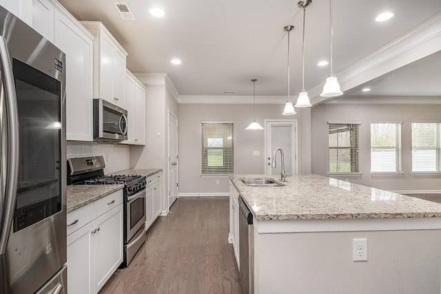 kitchen with tasteful backsplash, visible vents, a center island with sink, stainless steel appliances, and a sink