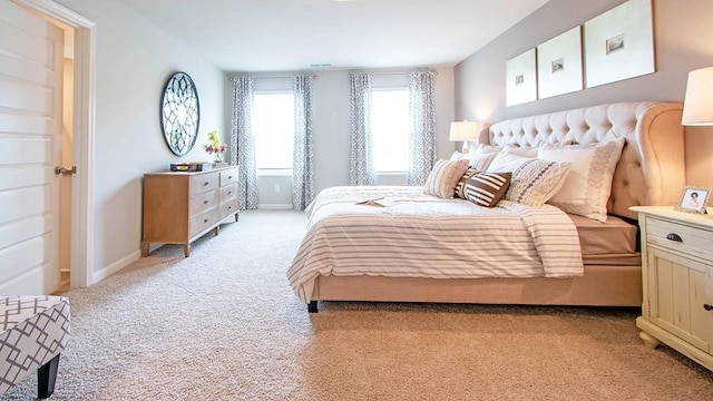 bedroom with baseboards and light carpet