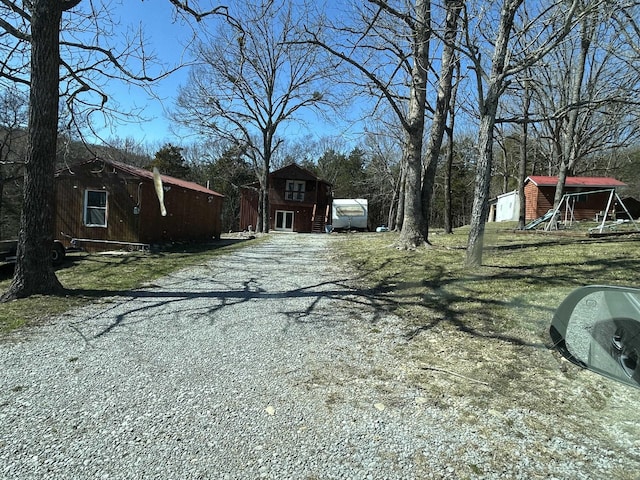 view of yard with an outbuilding and gravel driveway