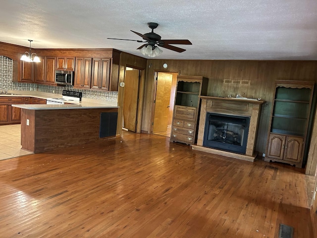 kitchen with visible vents, stainless steel microwave, hardwood / wood-style floors, white electric range oven, and light countertops