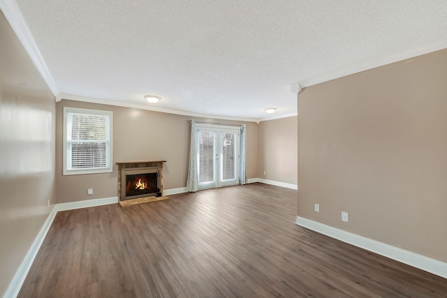 unfurnished living room with baseboards, dark wood finished floors, a lit fireplace, a textured ceiling, and crown molding