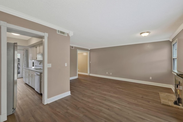 unfurnished living room with ornamental molding, wood finished floors, visible vents, and a sink