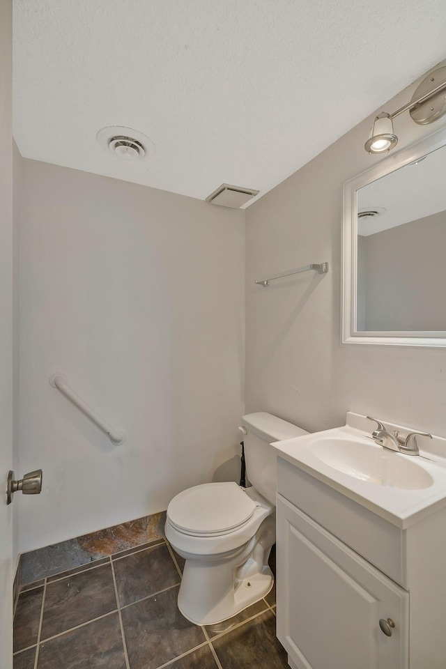 half bath with tile patterned floors, visible vents, toilet, and vanity