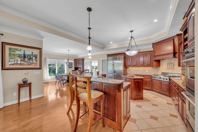 kitchen featuring backsplash, a kitchen island, brown cabinetry, custom exhaust hood, and stainless steel appliances