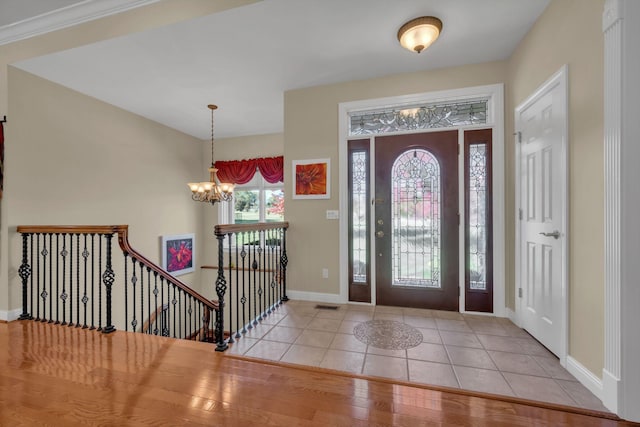 foyer with visible vents, baseboards, a notable chandelier, and tile patterned flooring