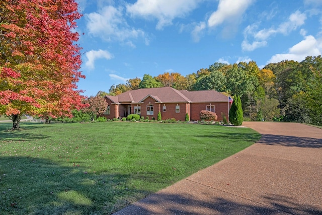 single story home featuring concrete driveway and a front lawn