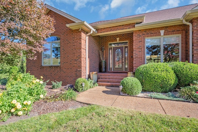 entrance to property featuring brick siding